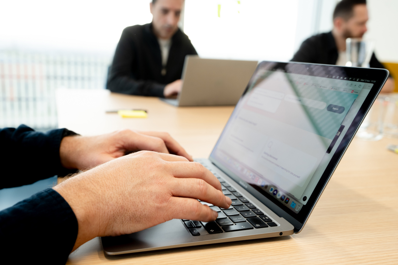 Close up of man typing on laptop in an office meeting room