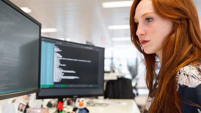 image of a women sitting at desk by computer